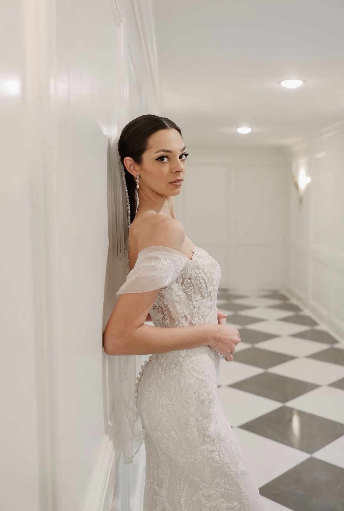 Real bride — soft glam and sleek low ponytail with veil in a checkered hallway
