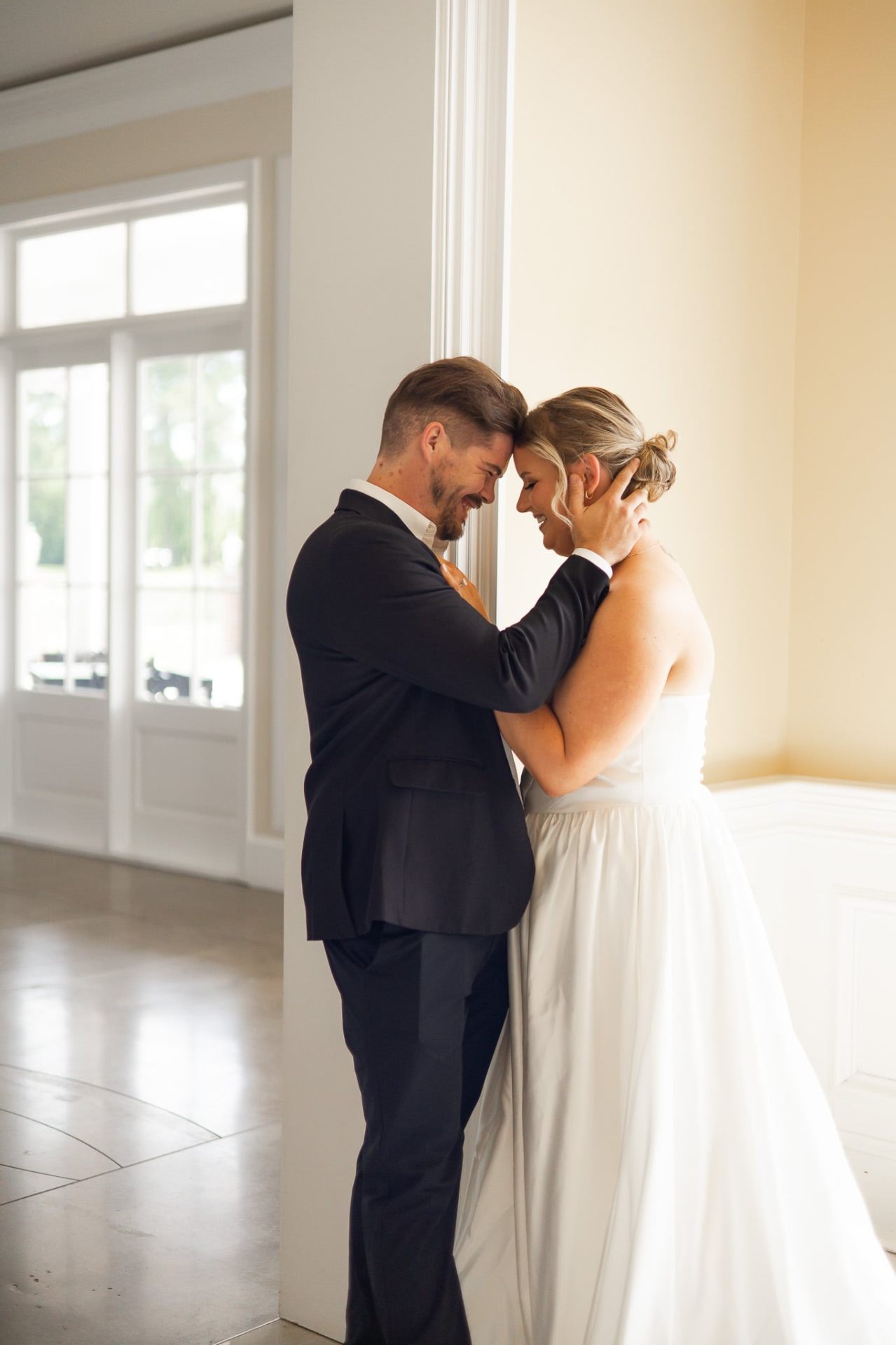 Real couple — first-look moment with soft bridal updo and natural glam